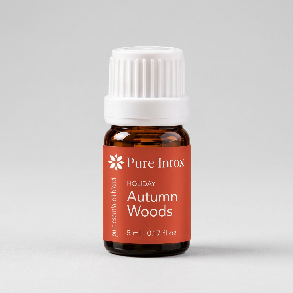 A 5 ml amber glass bottle of Pure Intox 'Holiday Autumn Woods' essential oil blend with a white ribbed cap and a terracotta orange label, set against a plain white background.