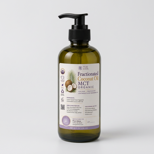 A bottle of Pure Intox Fractionated Coconut Oil MCT Organic in an amber glass pump bottle, styled on a wooden surface with coconuts, a knit blanket, and potted plants in the background.