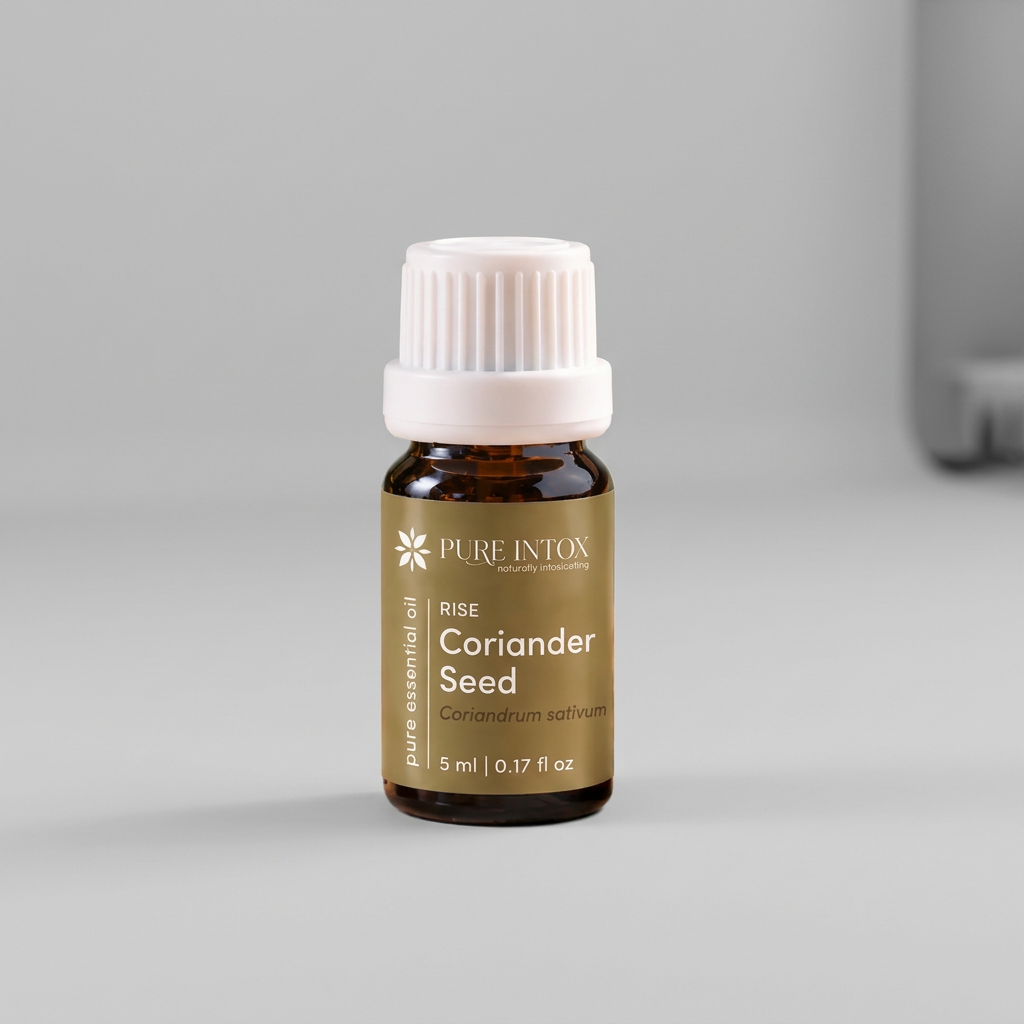 A bottle of Pure Intox 'Herb Coriander Seed' essential oil placed on a rustic wooden board surrounded by fresh coriander leaves, loose seeds, and a wooden bowl, with a blurred traditional mortar and pestle in the background.