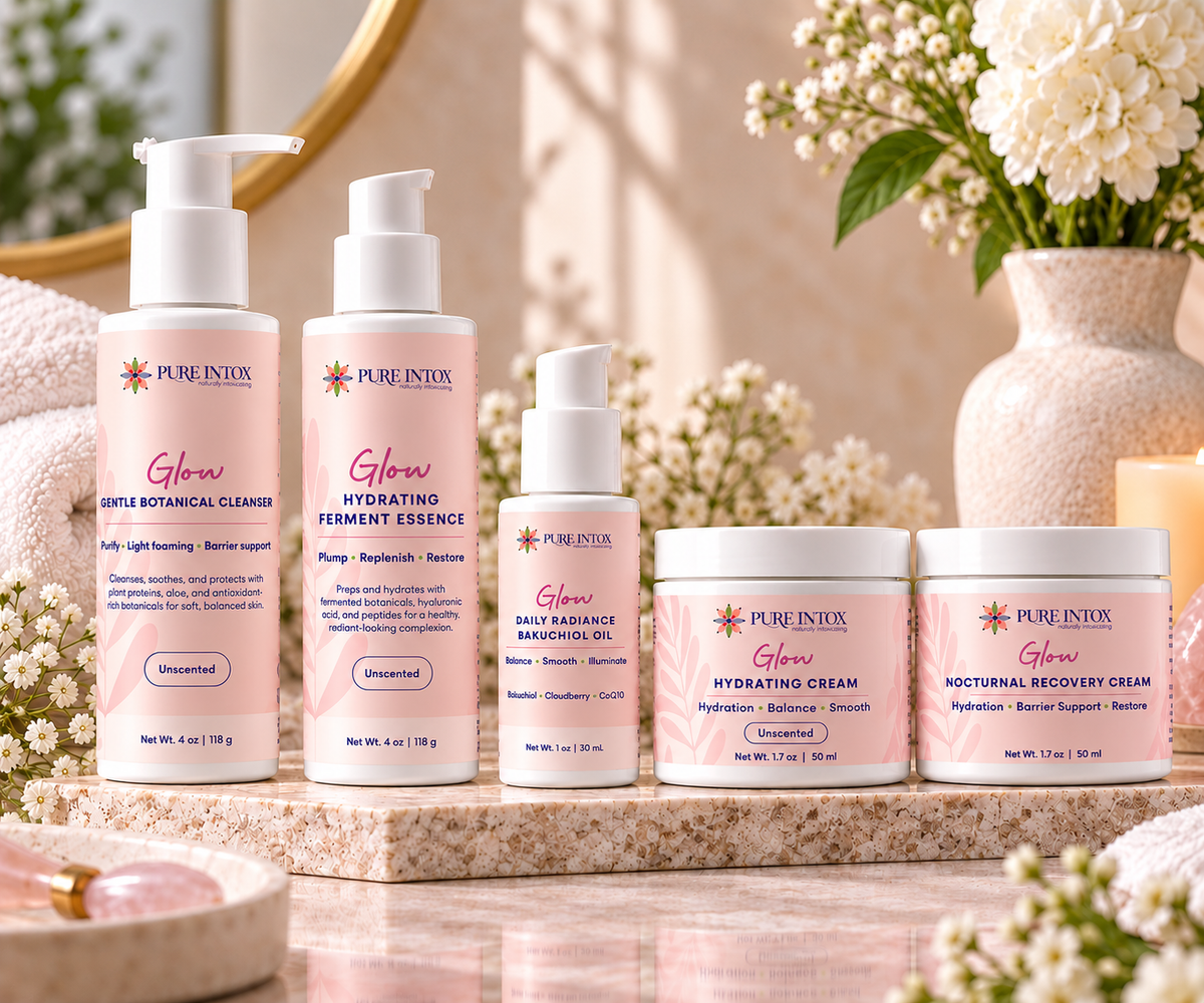 A set of five Pure Intox skincare products arranged on a marble tray with a spa-like background. The products include cleanser, hydrating ferment essence, daily resistance moisturizer, hydrating cream, and natural recovery cream in soft pink packaging with white text and pump/bottle tops.