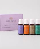 Four Pure Intox botanical aromatherapy oil bottles with white caps displayed in front of their lavender-colored product box on a white background.