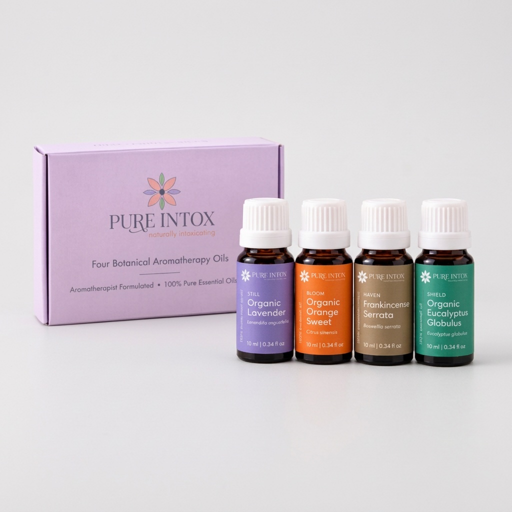 Four Pure Intox botanical aromatherapy oil bottles with white caps displayed in front of their lavender-colored product box on a white background.