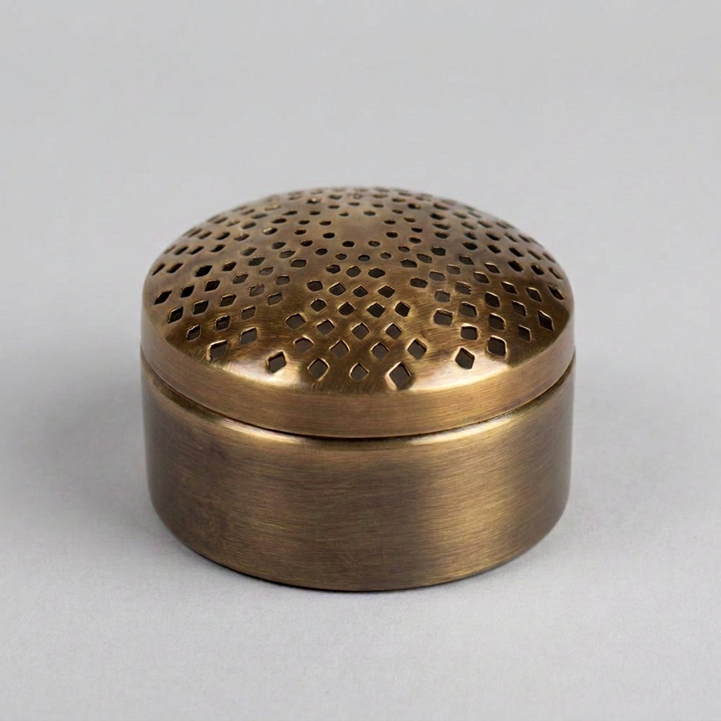 Bronze-colored metal container with perforated lid on a white background