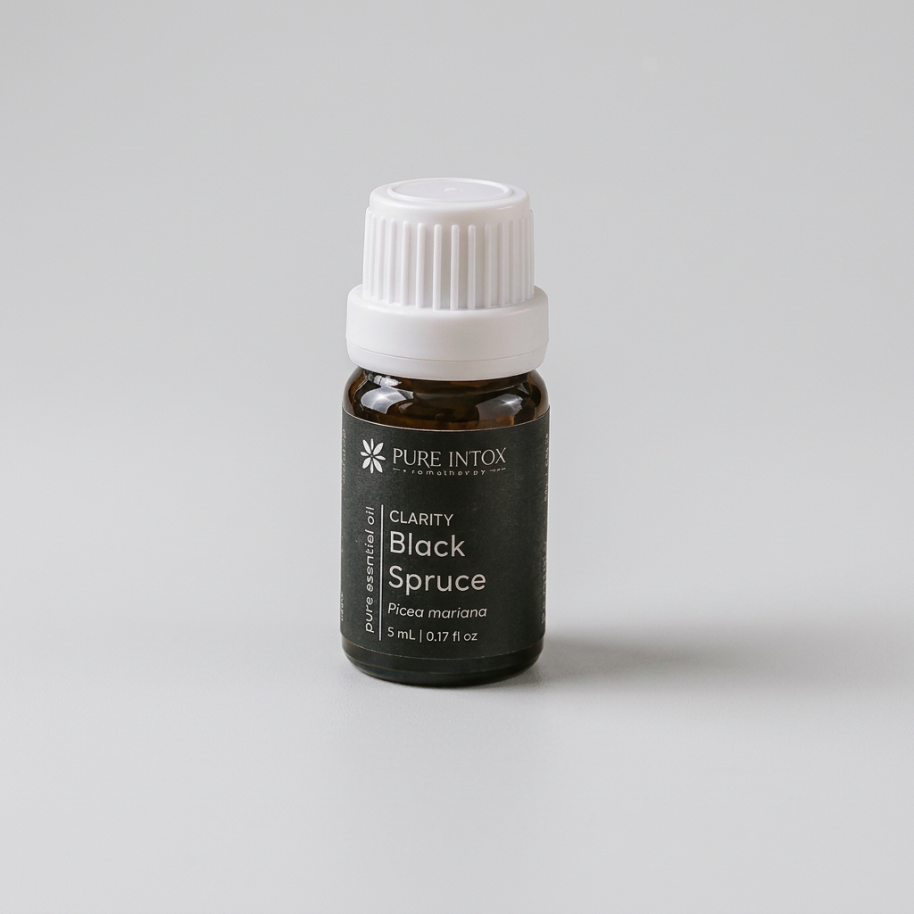 A small black glass bottle of Pure Intox Clarity Black Spruce essential oil with a white ribbed cap, styled on a stone with driftwood, pine needles, and burlap in an outdoor rustic setting.