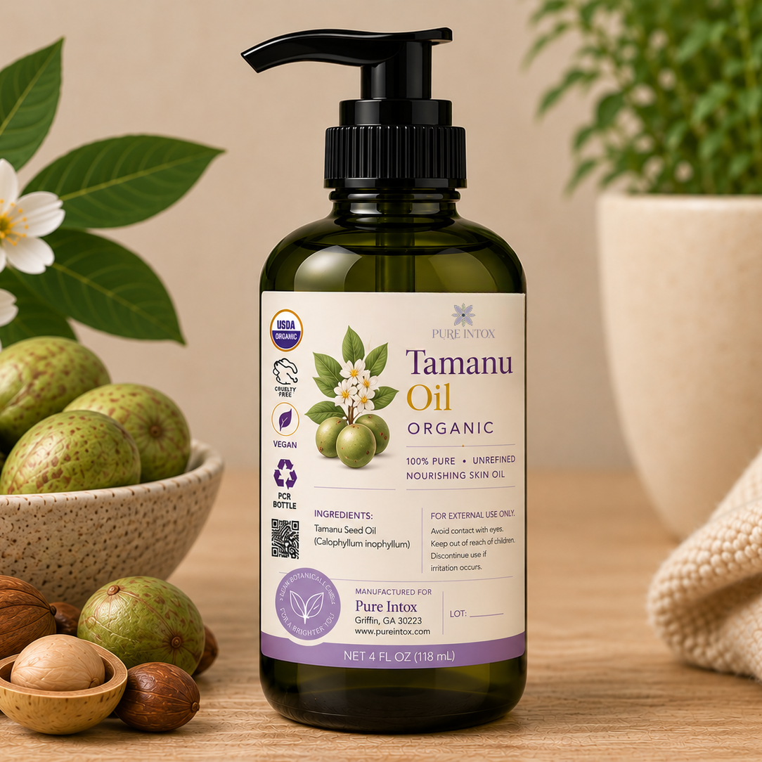 A bottle of Pure Intox Tanamu Oil Organic in a dark green glass bottle with a black pump, styled on a wooden surface with green leaves, white flowers, green fruits, walnuts, and a beige knitted blanket in the background.